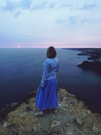 Woman looking at sea against sky