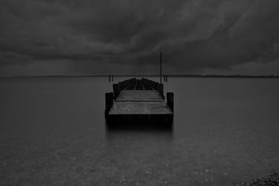 Boat on sea against storm clouds
