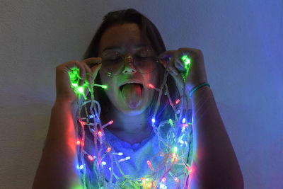 Portrait of young woman with multi colored light painting