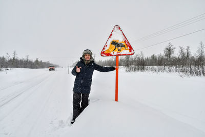 Rear view of woman standing on snow covered field