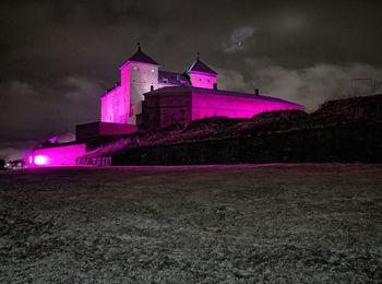 Low angle view of illuminated building against sky at night