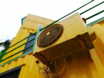 Low angle view of yellow camera against sky