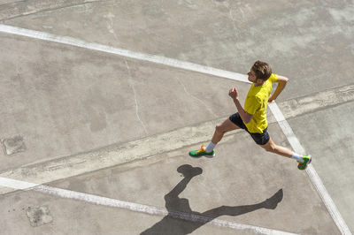 Young man jogging, concrete floor