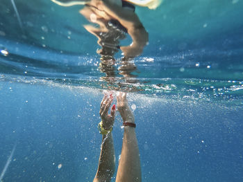 Cropped woman swimming in sea