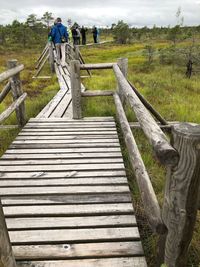 Rear view of man climbing on footbridge