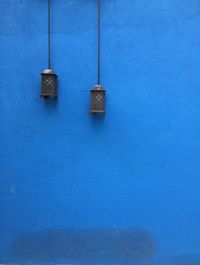 Lanterns hanging by blue wall