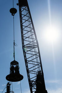 Low angle view of communications tower against sky on sunny day