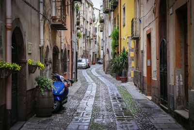 Vehicles parked on alley amidst buildings