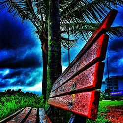 Railroad tracks on field against cloudy sky