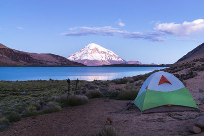 Scenic view of tent by mountain against sky