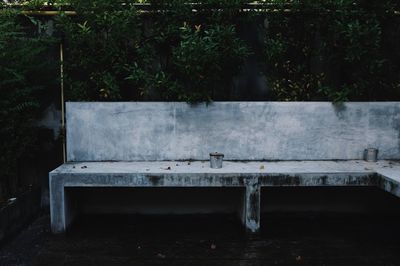 Small garbage bins on bench against trees