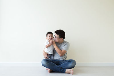 Young couple sitting against white background