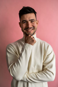 Portrait of young man standing against yellow background