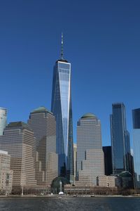 Skyscrapers in city against blue sky