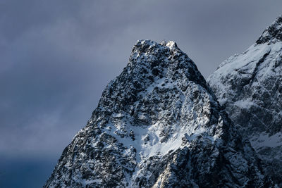 Low angle view of snow covered mountain against sky