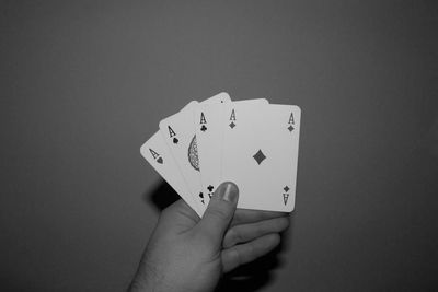 Close-up of hand playing guitar against black background