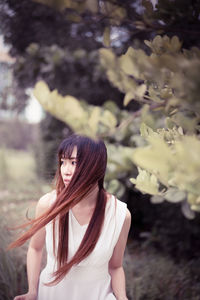 Midsection of woman standing by flowering plants