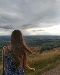 Rear view of woman looking at landscape against sky