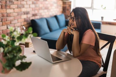 Young woman using laptop at home