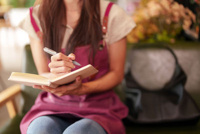 Midsection of woman using mobile phone