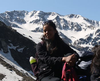 Full length of woman standing on snowcapped mountain