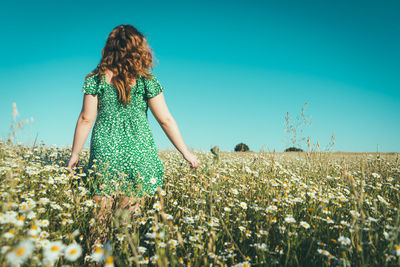 Full length of woman standing on field against sky