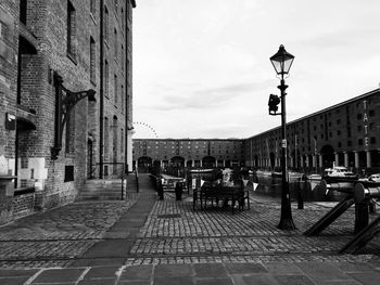 People on street in city against sky