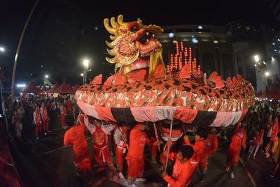 People carrying chinese dragon during event in city