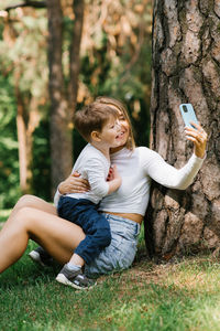 European family having fun, a mother and her son taking a selfie with a mobile phone in the park