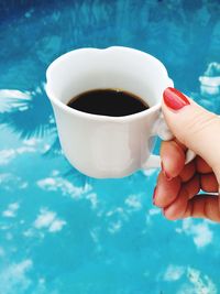 Close-up of hand holding coffee cup