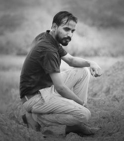 Young man sitting on field