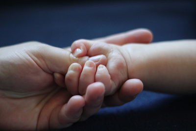 Close-up of mother holding baby hand