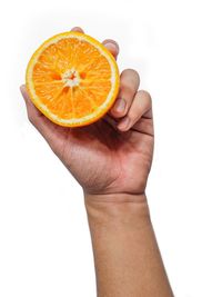 Close-up of hand holding apple against white background