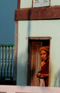 Full length of smiling woman standing against wall