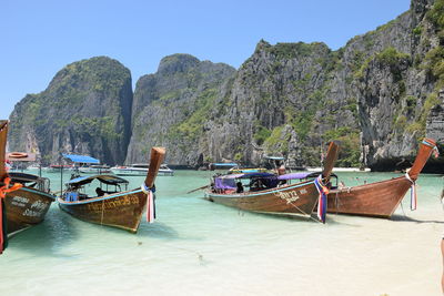 Boats moored on sea against clear sky