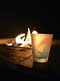 Close-up of lit candles on table