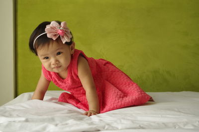 Portrait of cute girl lying on bed at home