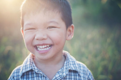 Close-up portrait of happy boy during sunny day