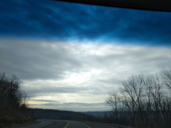 Road amidst field against sky