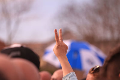 Midsection of man with arms raised in background