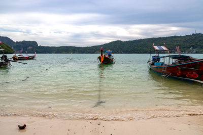 Boats moored on sea against sky