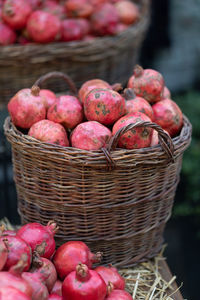 Harvest of ripe pomegranate on dry straw at outdoor farmer market in turkey. vegetarian healthy food