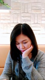 Close-up of beautiful young woman sitting at home
