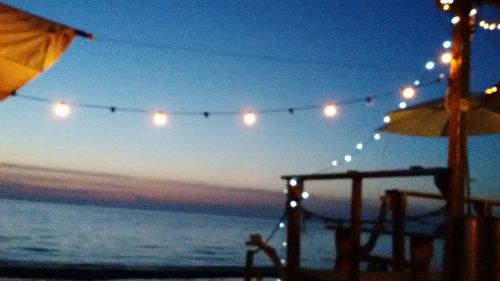 Close-up of illuminated sea against sky at sunset