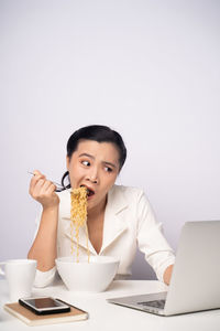 Young woman using phone while sitting on table