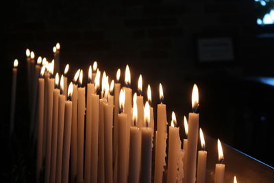 Close-up of illuminated candles in temple
