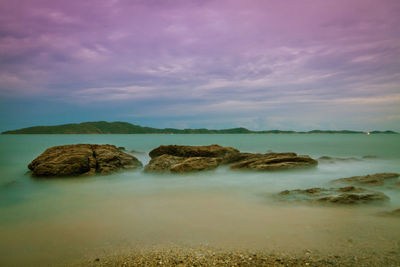 Rocks on sea shore against sky