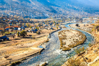 High angle view of houses and trees against mountains