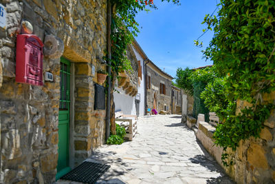 Street amidst houses and buildings against sky