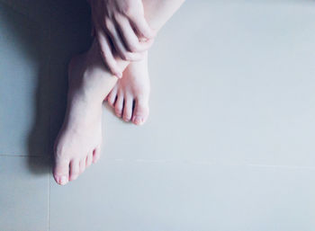 Low section of woman legs on tiled floor